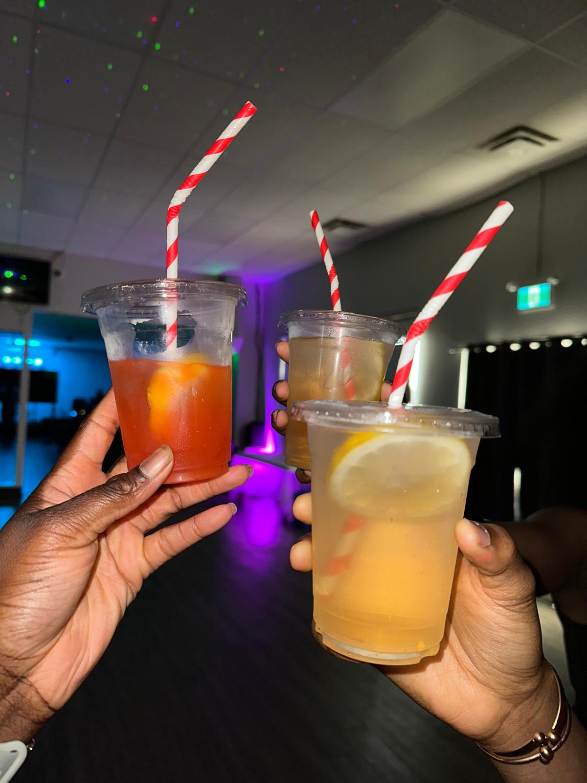 Guests holding three colourful Nektar mocktails at an evening event